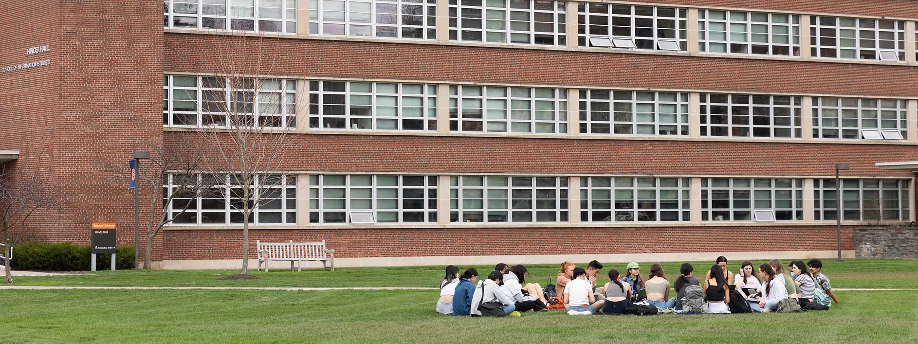 students sitting on a lawn on campus