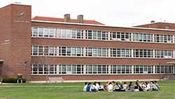 students sitting on a lawn on campus